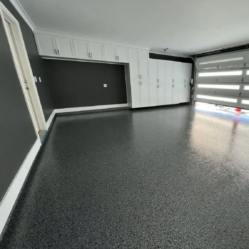 Modern garage with white cabinets and gray epoxy floor