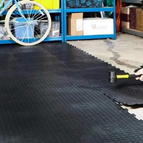 storage garage area showing a section of black, coin-patterned interlocking PVC tiles