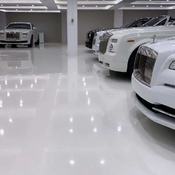 white epoxy floor in a luxury car showroom reflecting several Rolls-Royce vehicles parked in a row