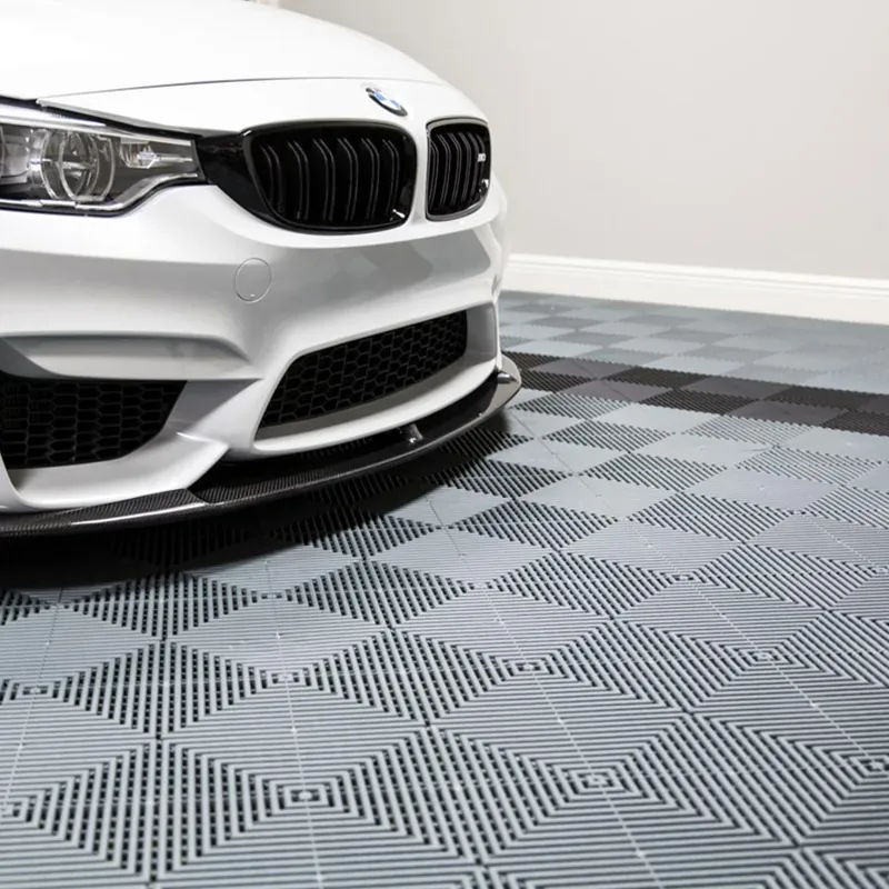 White BMW M4 with black grille on grey interlocking PVC garage flooring