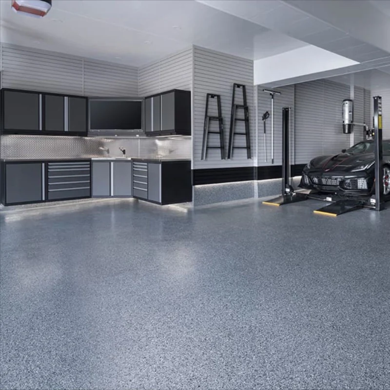 Modern garage with epoxy flooring, storage cabinets, and a car lift.