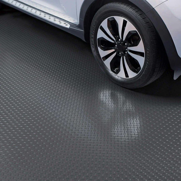 Diamond plate PVC garage flooring under a car tire.
