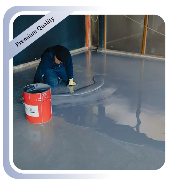 Worker applying grey epoxy floor coating in a room