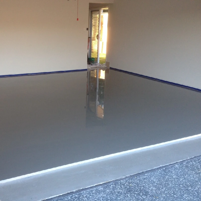 Newly painted gray epoxy garage floor with blue trim and a reflective surface.