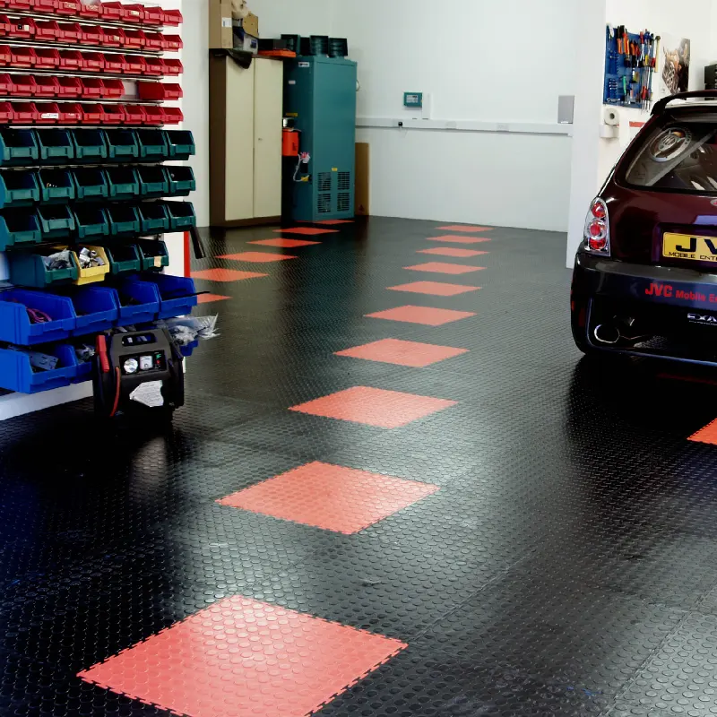 Garage Flooring Tiles 70 Black coin-top garage flooring tiles with a path of red tiles leading to a car.